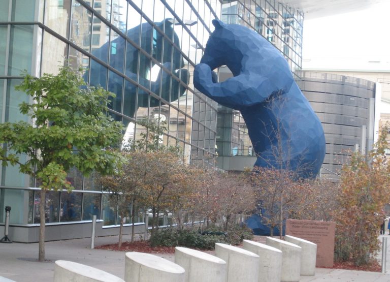 blue bear statue peering into Denver Convention Center