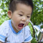 boy drinking from water fountain