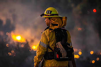firefighter with fire in background