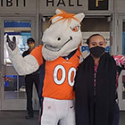 Broncos mascot and masked woman