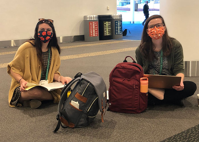 two masked women sitting on floor