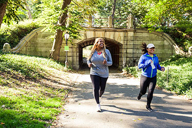 smiling women jogging in park