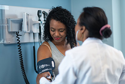 doctor checks woman's blood pressure