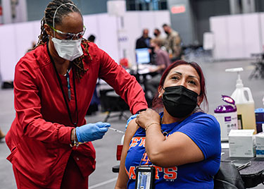 masked woman being vaccinated