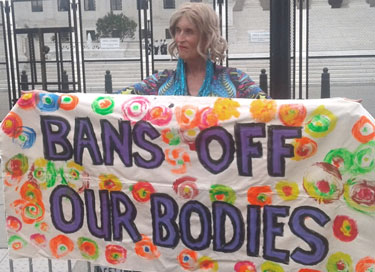 Woman holds sign protesting SCOTUS ruling