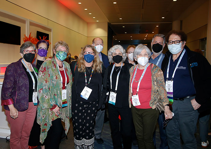 A group of 10 attendees with masks on pose for the camera. 