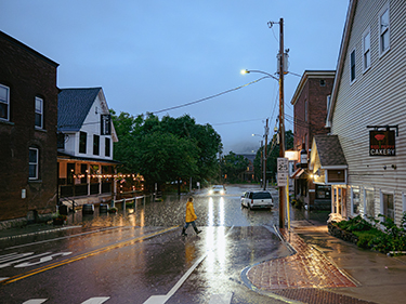 Person walks across flooding road in Vermont