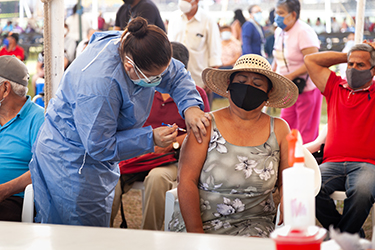 Photo of public health worker vaccinating a person at clinic