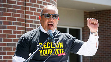 Marc Morial speaks at an event wearing a shirt saying "Reclaim Your Vote"