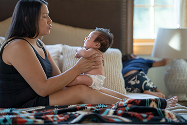 Pregnant woman plays with baby