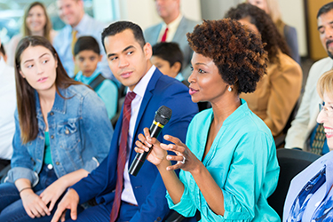 A citizen speaks to an elected leader at a town hall