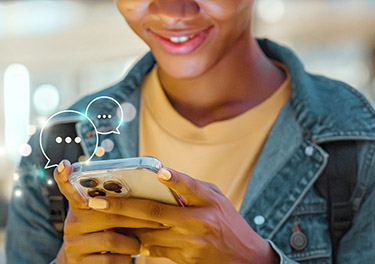 A teen reads a message on a cell phone