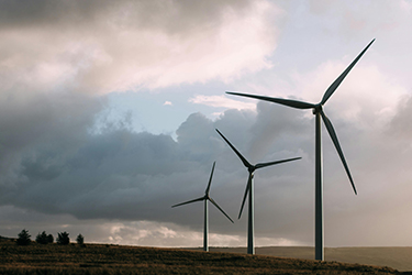 Turbines are shown on a prairie under cloudy skies