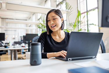 A woman works at laptop computer