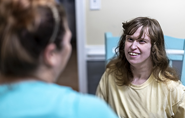 A woman with intellectual and developmental disabilities talks to a health care worker.