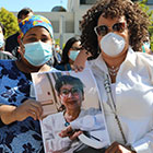 masked health workers holding photo of colleague