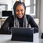 Woman smiling in front of laptop computer