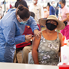 A health worker vaccinates a person