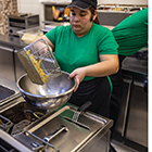 A fast food worker prepares French fries