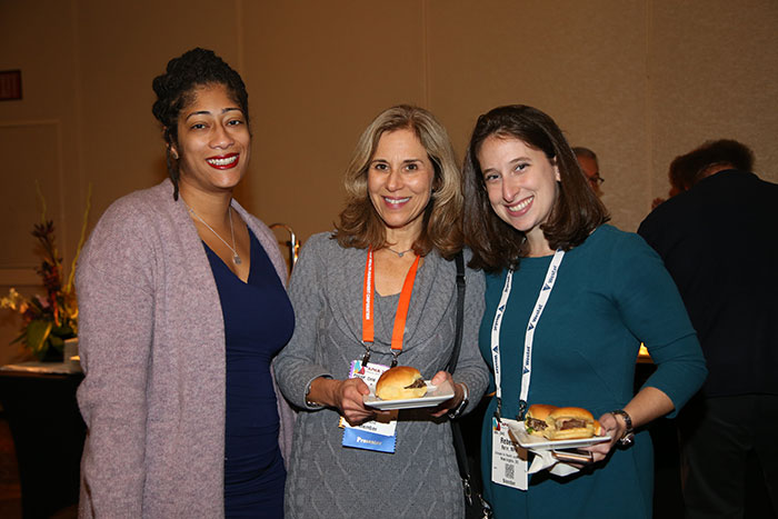 three smiling women with plates of food